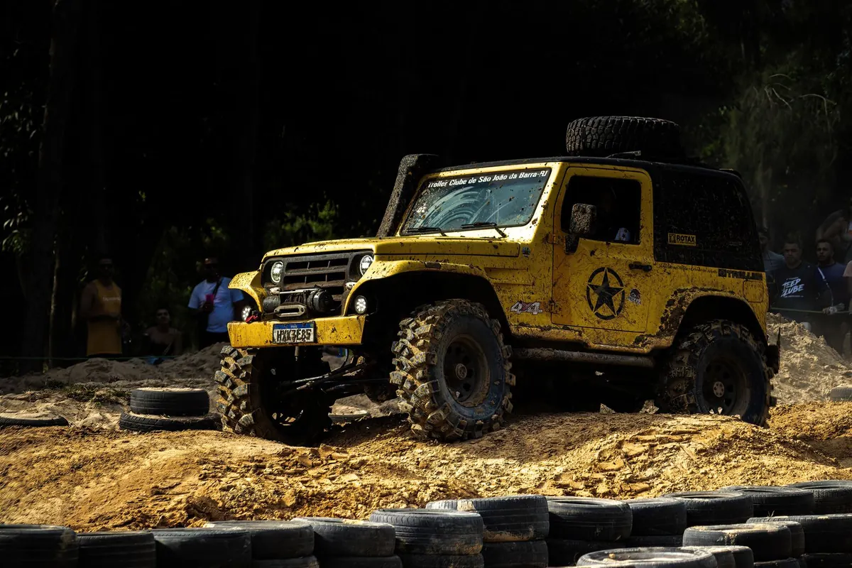 Yellow 4x4 off-road vehicle climbing over rough terrain