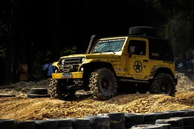 Yellow 4x4 off-road vehicle climbing over rough terrain