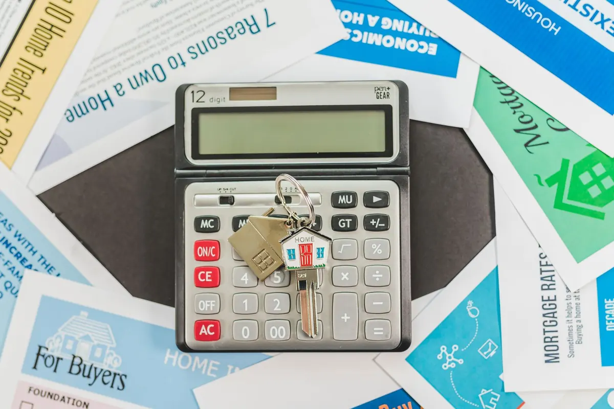 Calculator and house keys on top of mortgage leaflets