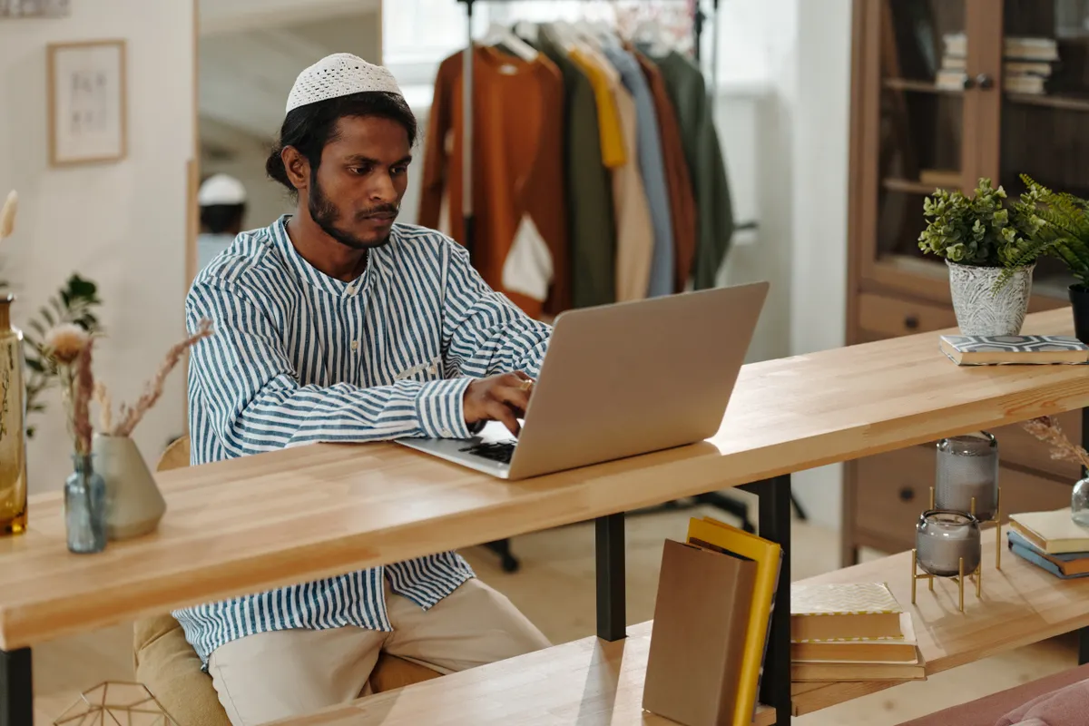 Person working at a laptop in a bright home office, reviewing software on screen