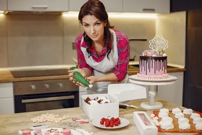 Baker decorating a celebration cake in her kitchen