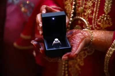 Diamond engagement ring in a lit ring box held by a bride