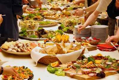 Guests serving themselves from a colourful wedding buffet