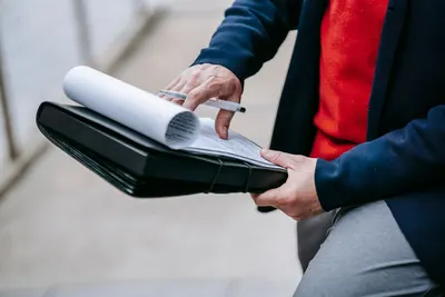 Professional reviewing printed documents in a folder